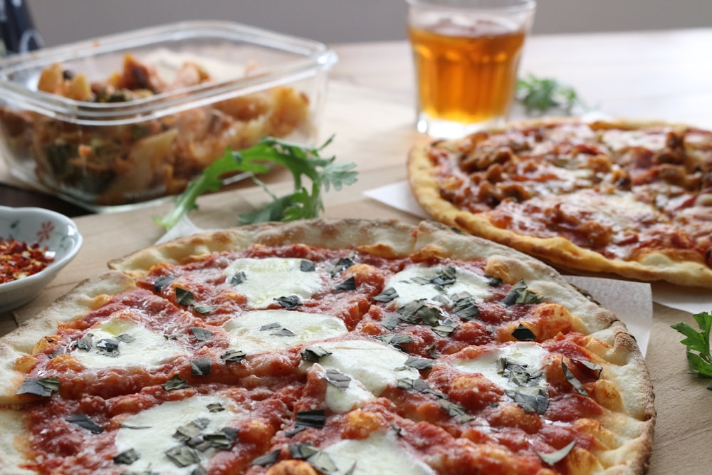 pizza with green leaves on clear glass plate