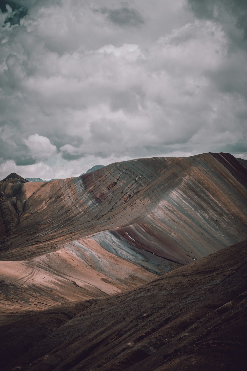 brown rocky mountain under gray clouds