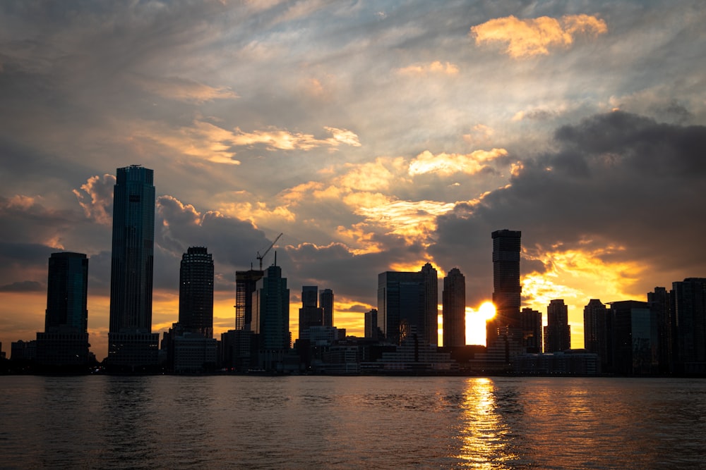 Horizonte de la ciudad a través del cuerpo de agua durante la puesta del sol