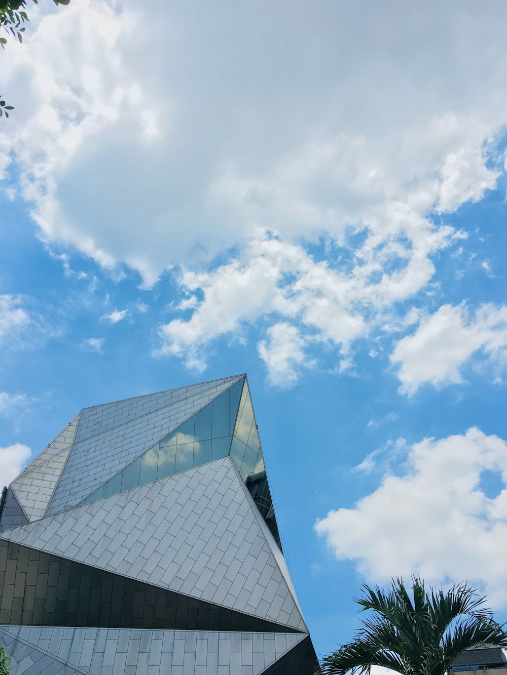 gray concrete building under blue sky and white clouds during daytime