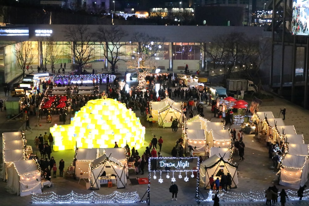 people sitting on chairs under yellow umbrella during night time