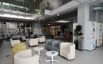 Cozy library seating area with warm lighting and fans in a modern setting.