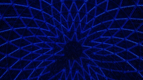 Elegant navy blue and gold geometric pattern framing a globe with diverse people connected by light beams.