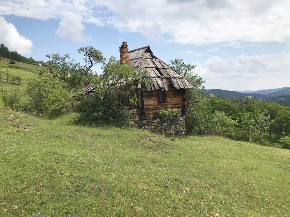 brown wooden house on green grass field during daytime