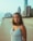 woman in white and black stripe tank top standing on beach during daytime