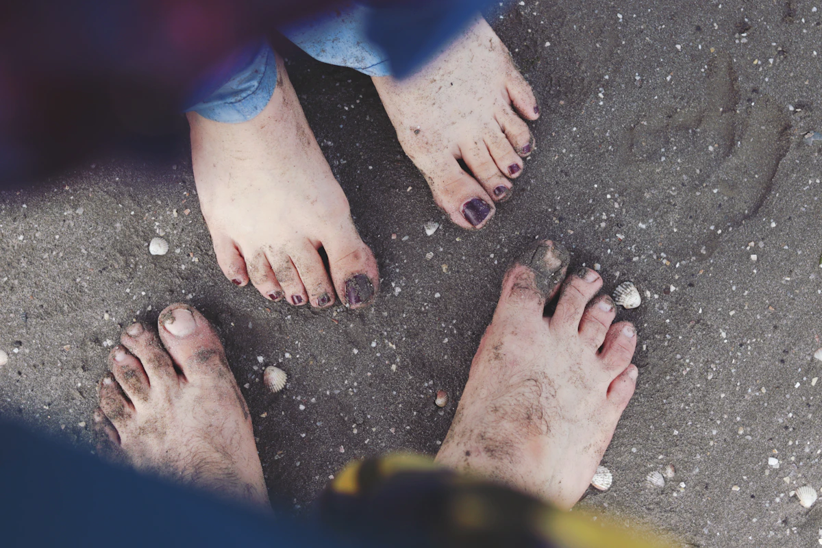 Bare feet planted on dark soil, grounding the root chakra