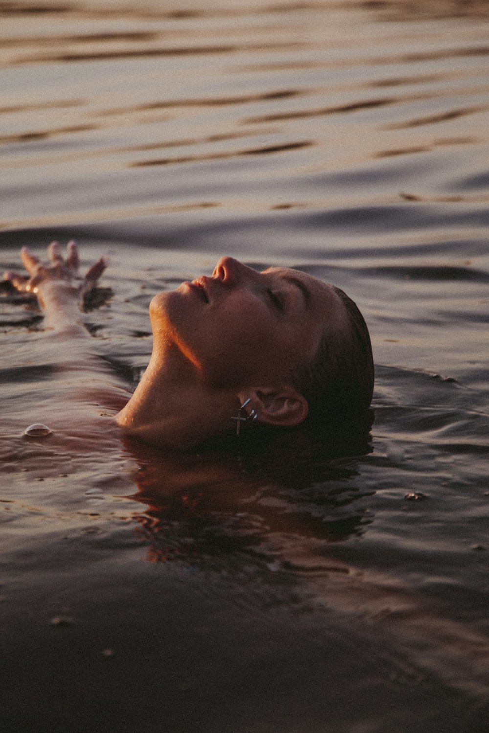 mujer en el agua con pétalos blancos
