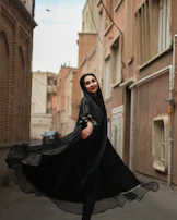 A candid shot of a woman twirling in a flowing dress on a cobblestone street.