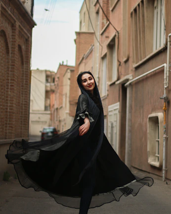 A candid shot of a woman twirling in a flowing Vastraaura dress on a cobblestone street