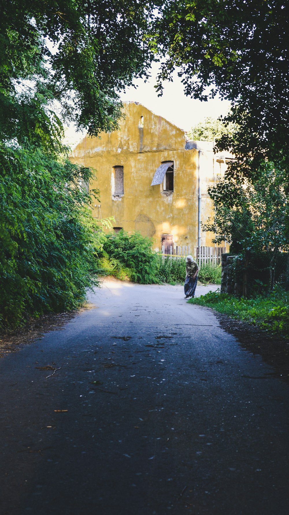 person in black jacket walking on gray concrete road during daytime