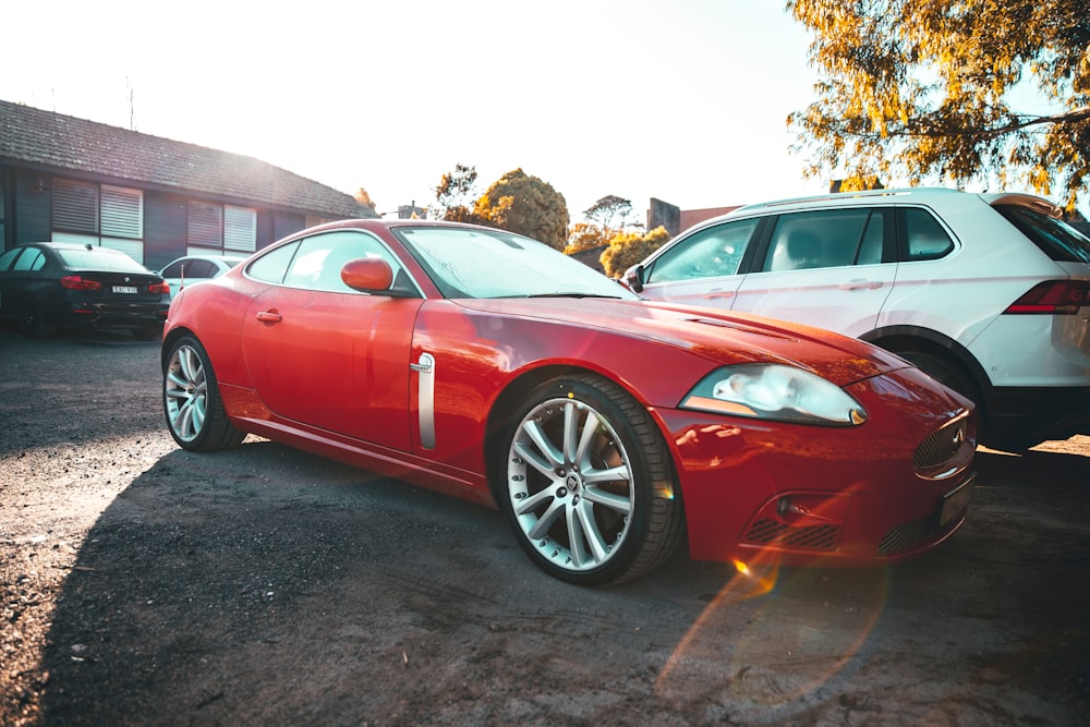 red coupe parked on parking lot during daytime