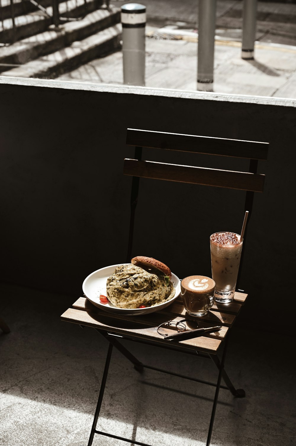 cooked food on white ceramic plate beside clear drinking glass on brown wooden table