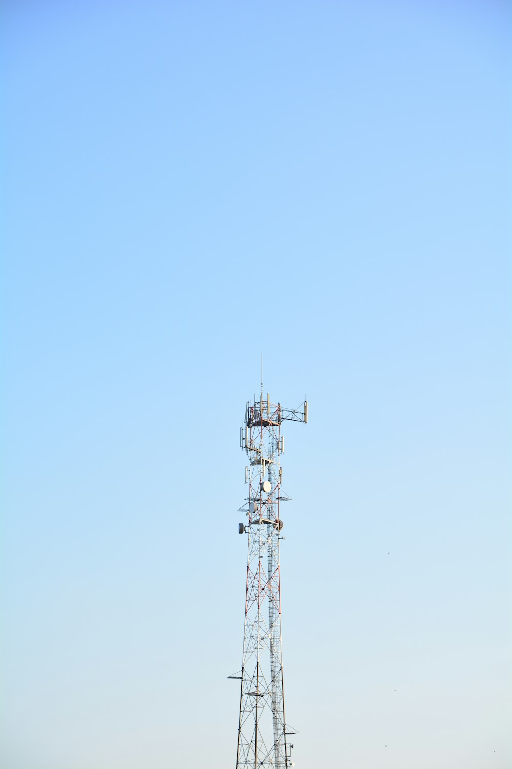 Torre de metal blanco y negro bajo el cielo azul durante el día