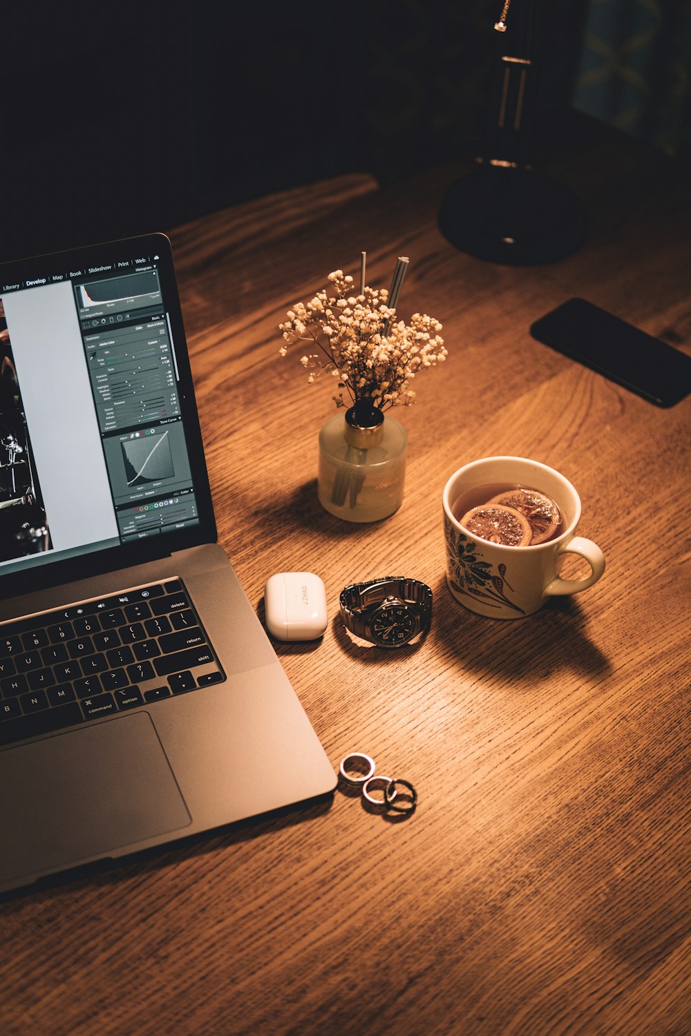 macbook pro beside white ceramic mug and black iphone 4 on brown wooden table