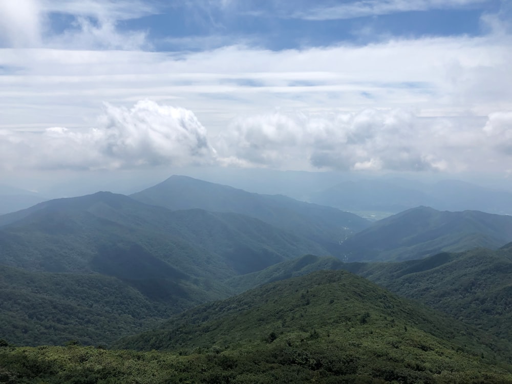 green mountains under white clouds during daytime