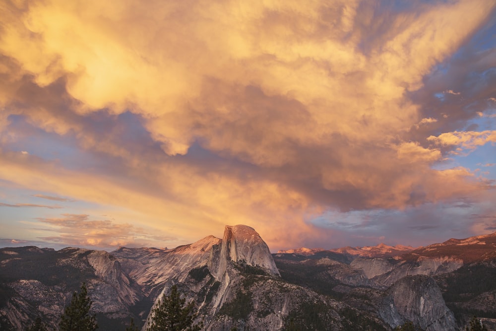 brown and white mountains under cloudy sky during daytime