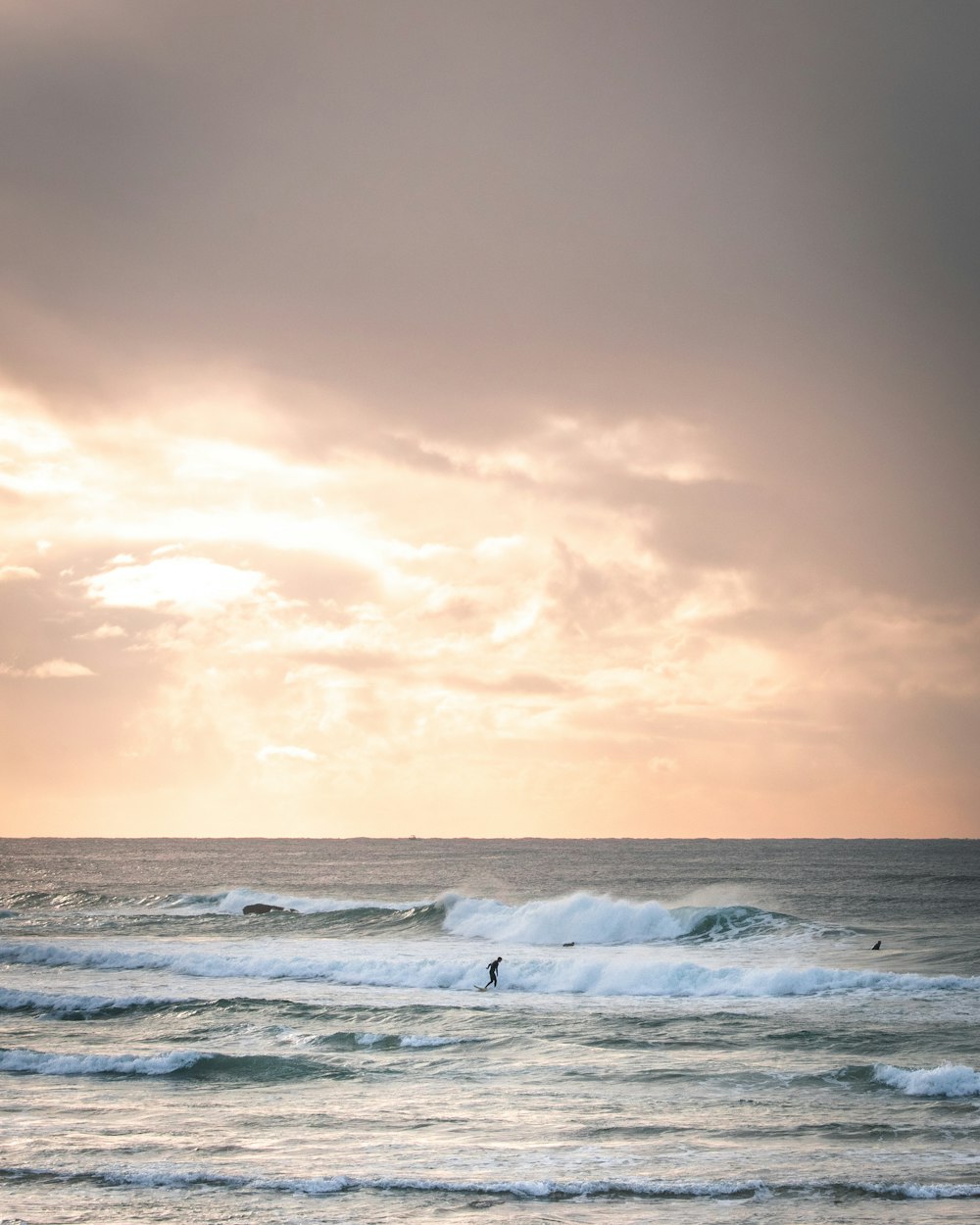 ocean waves crashing on shore during sunset