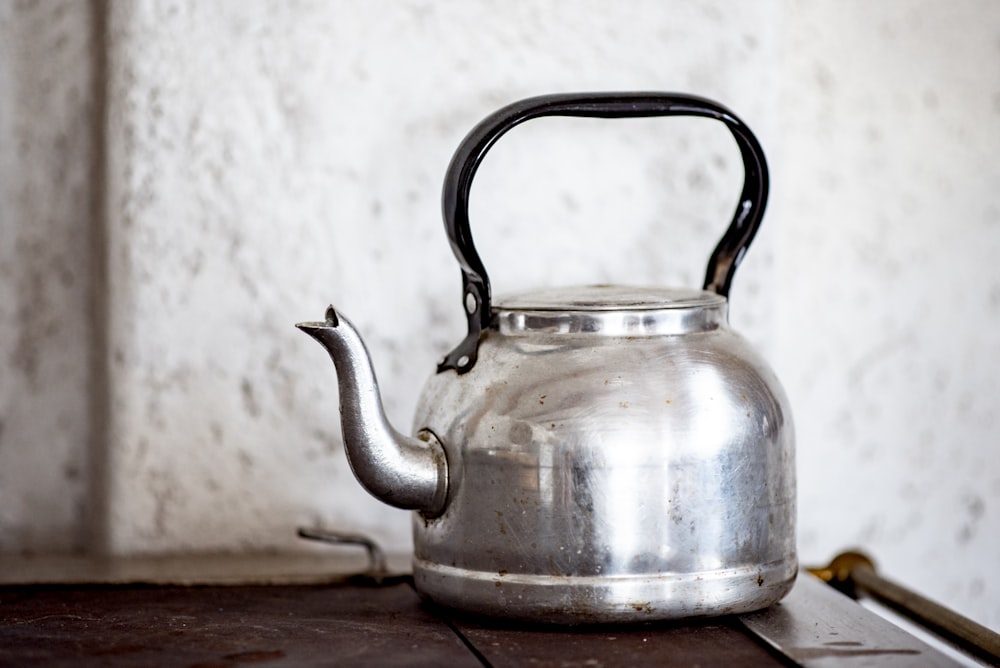 stainless steel kettle on brown wooden table