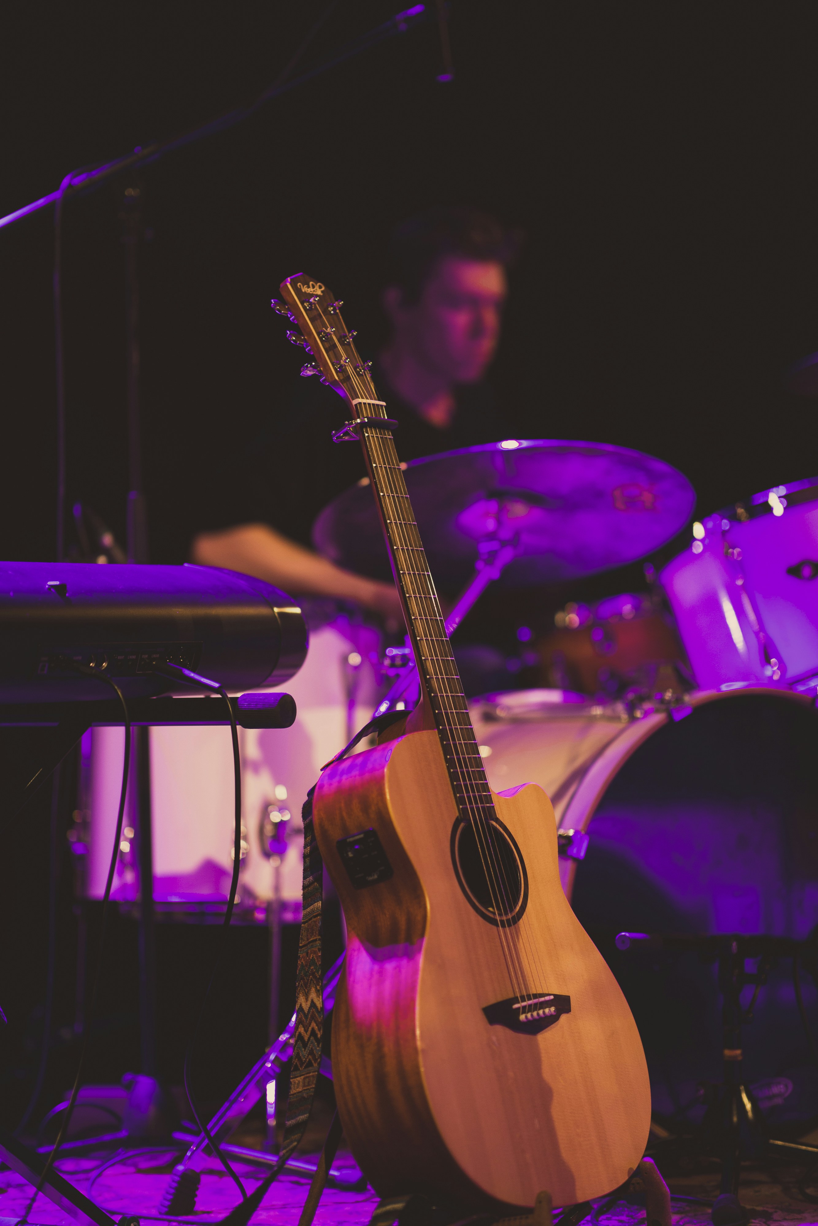 brown acoustic guitar on black guitar stand