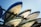 A stack of several speedboats are stored on metal racks under a clear blue sky. The boats are positioned upside down, showing their hulls which have different colors and markings.