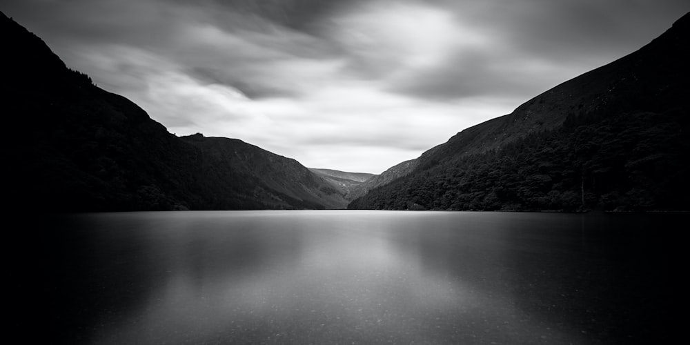 grayscale photo of lake and mountains