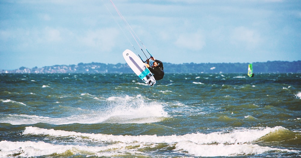 man surfing on sea waves during daytime