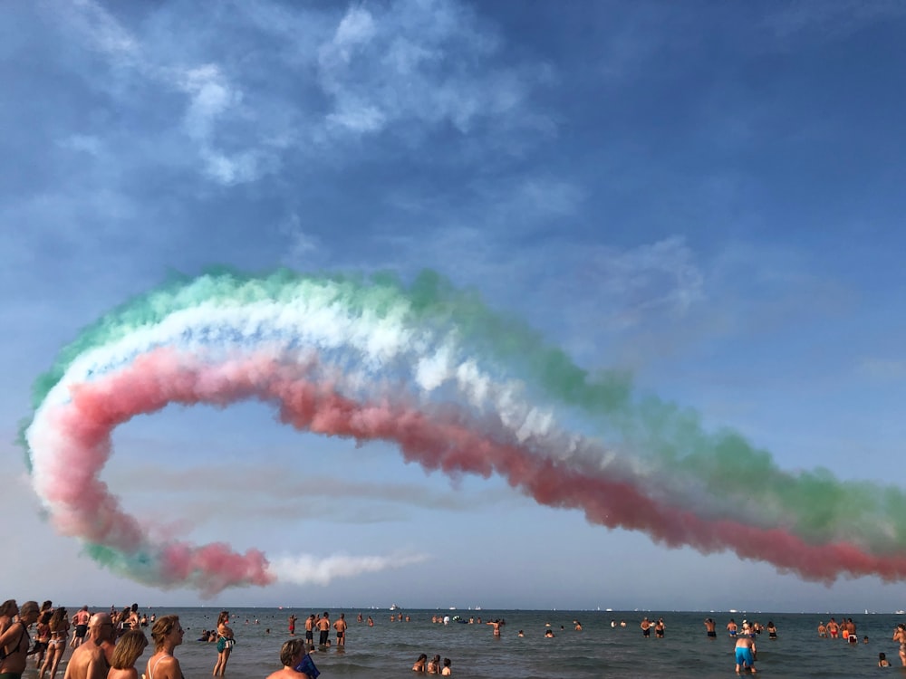 people on beach under blue sky with pink clouds during daytime