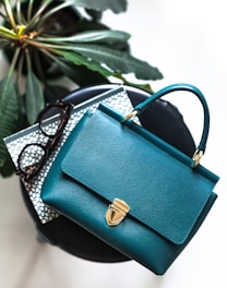 blue leather handbag on black leather bag