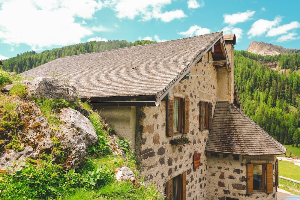 brown concrete house on green grass field during daytime