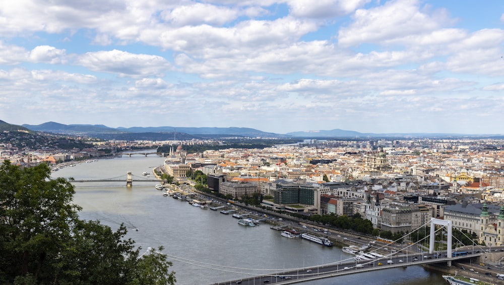 Bâtiments de la ville près d’un plan d’eau sous un ciel nuageux ensoleillé bleu et blanc pendant la journée