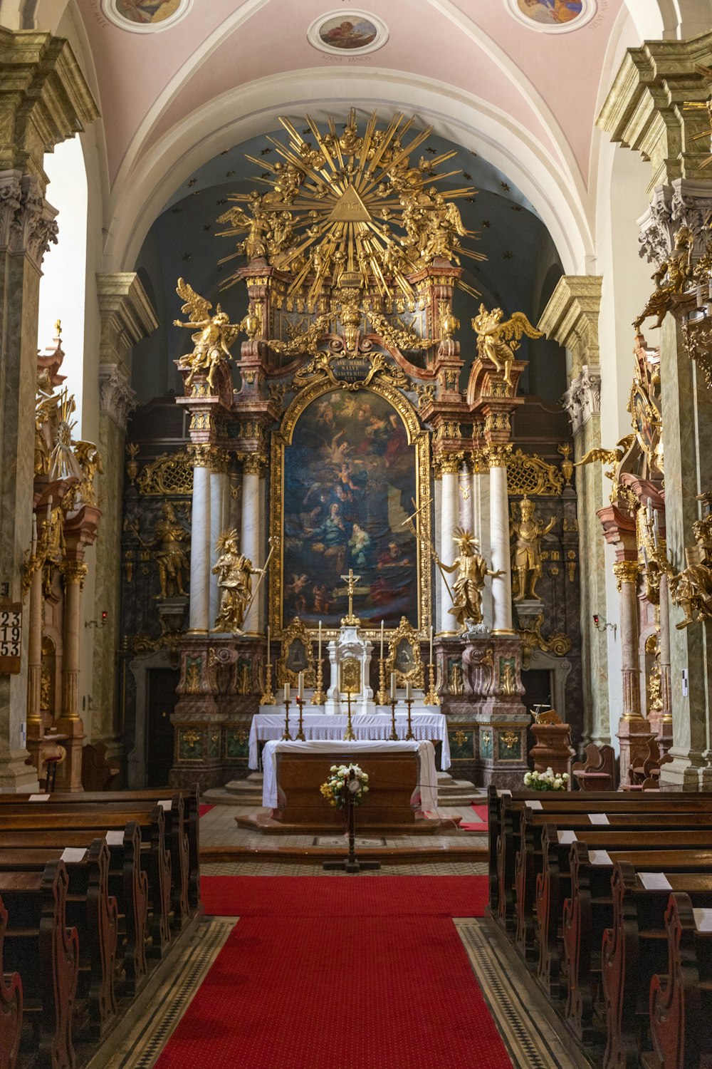 Una iglesia con una alfombra roja y un altar dorado