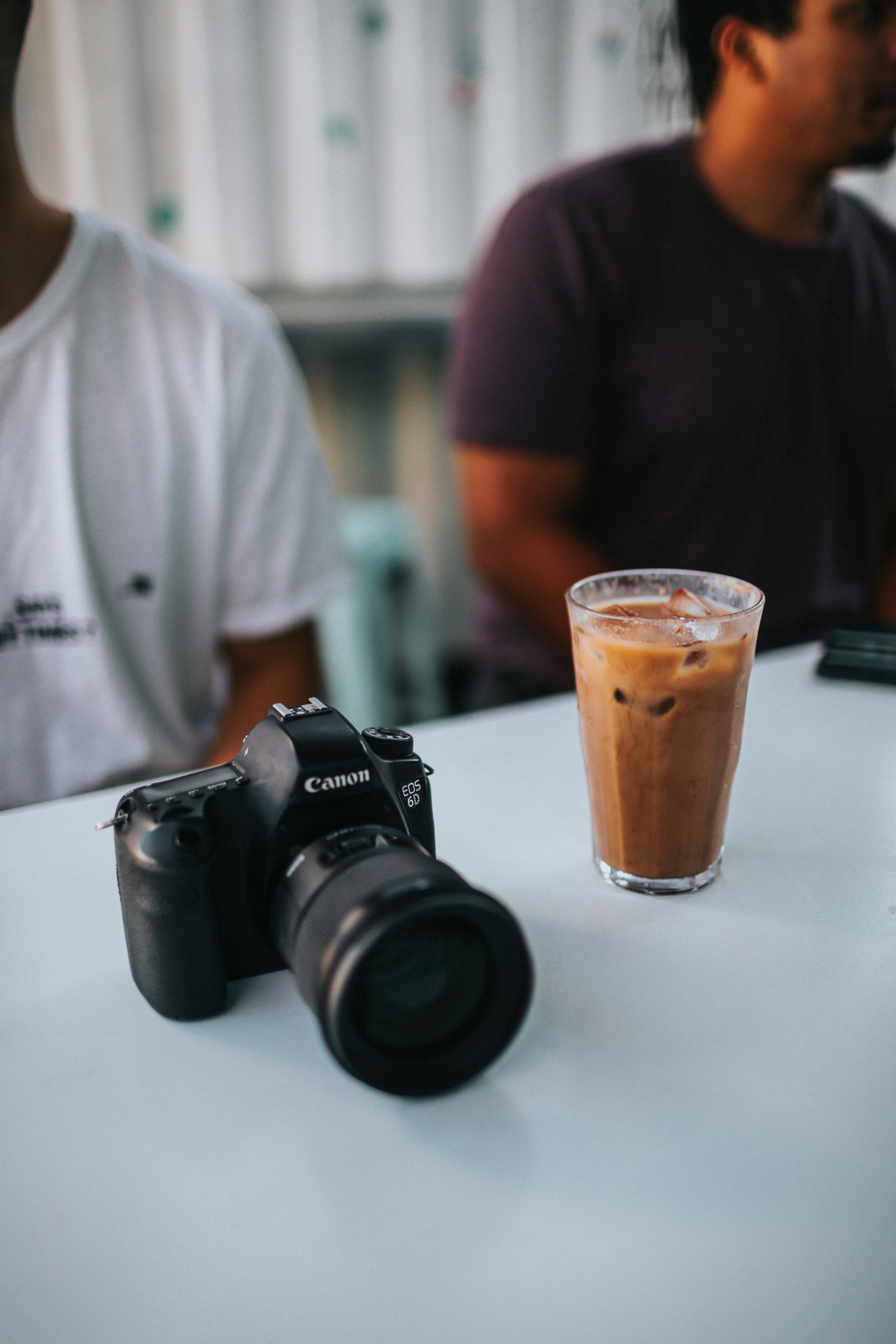A camera and a cup of coffee on a table photo – Free Human Image on ...