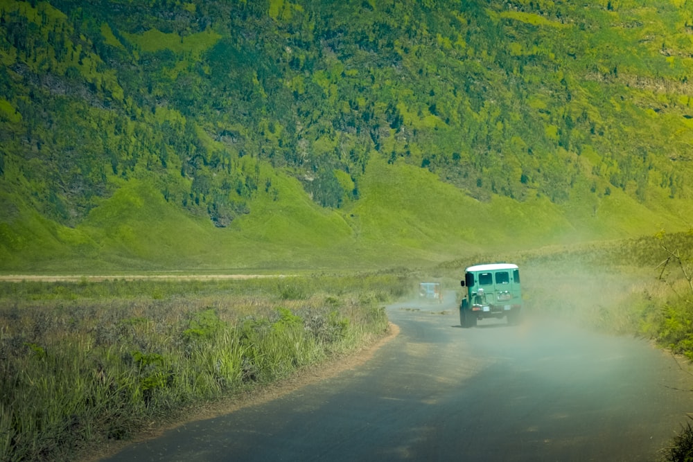 white and blue suv on dirt road during daytime