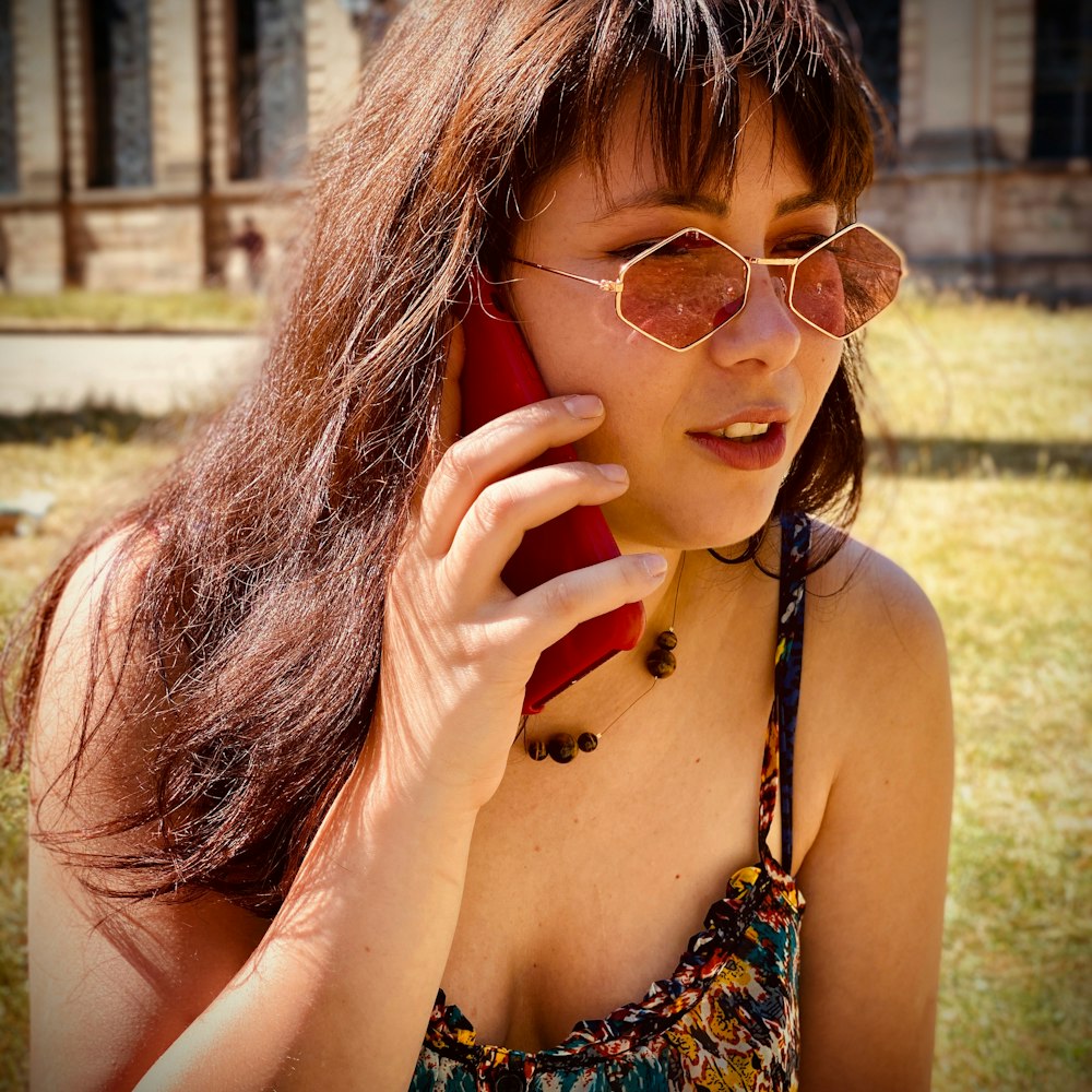 woman in black and red floral tank top wearing gold framed aviator sunglasses