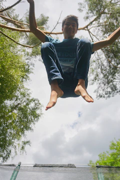 A vibrant photo showing a person mid-jump in a sunlit park.