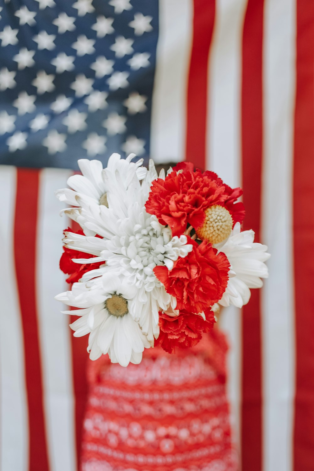 white and red flowers in red vase