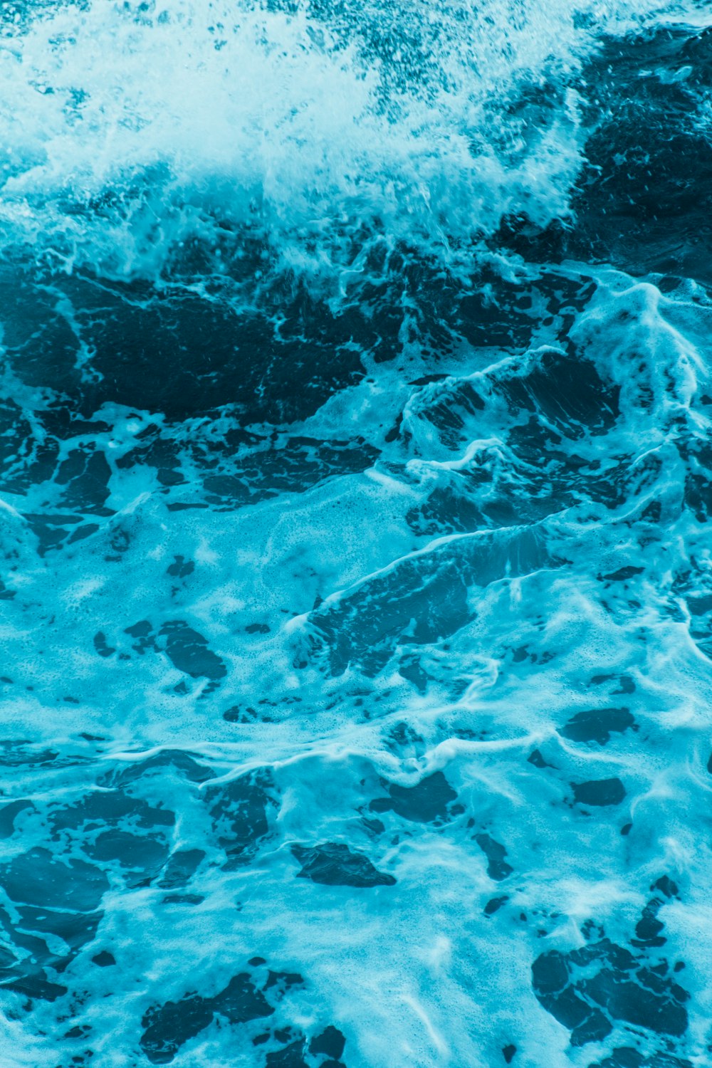 water waves on blue body of water