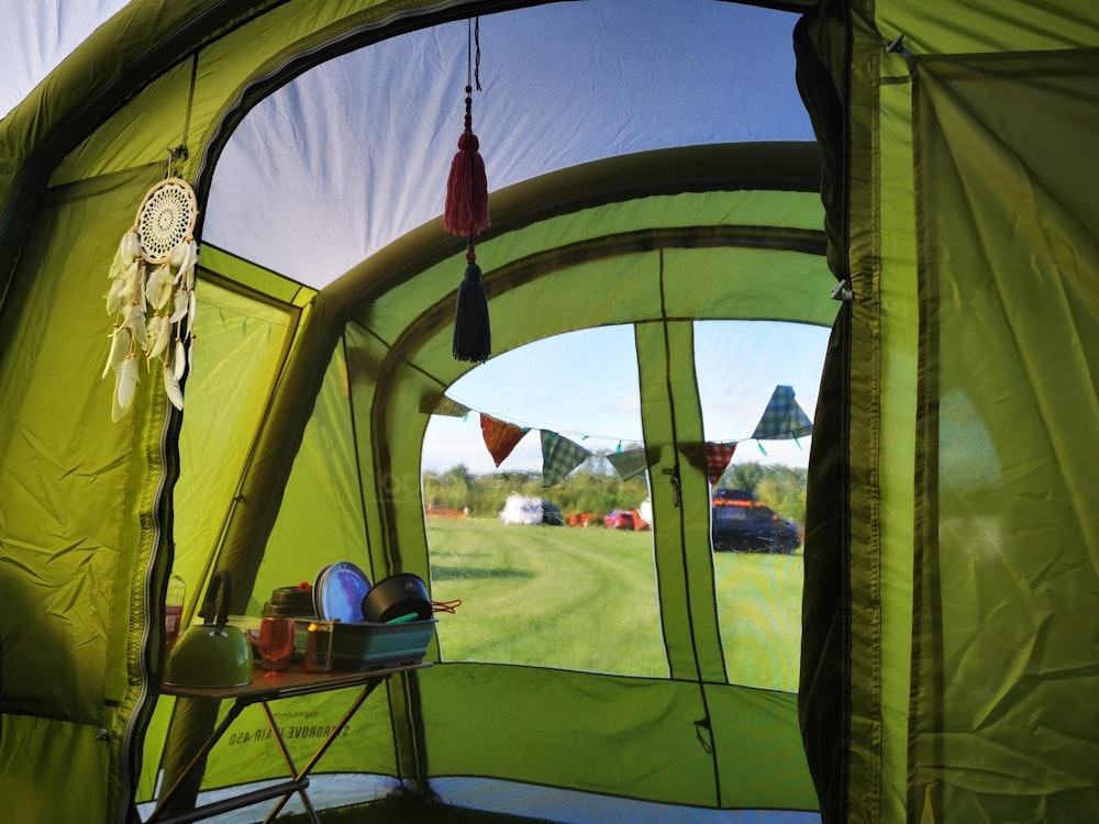 red and black tent near green grass field during daytime