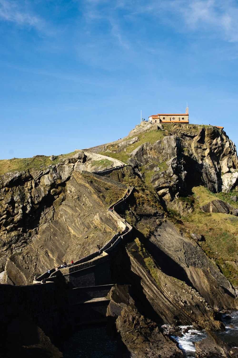 uma casa no topo de um penhasco à beira-mar