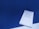 A spiral notebook is placed on a blue surface with a visible checklist handwritten in blue ink. The checklist includes various tasks, some marked with check marks, and dates are noted at the top of the page.