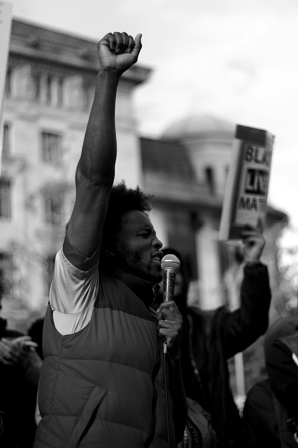 man in white t-shirt raising his right hand