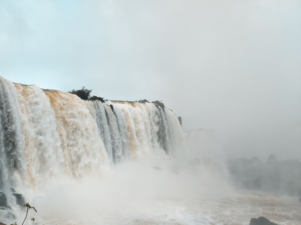 waterfalls under gray cloudy sky during daytime