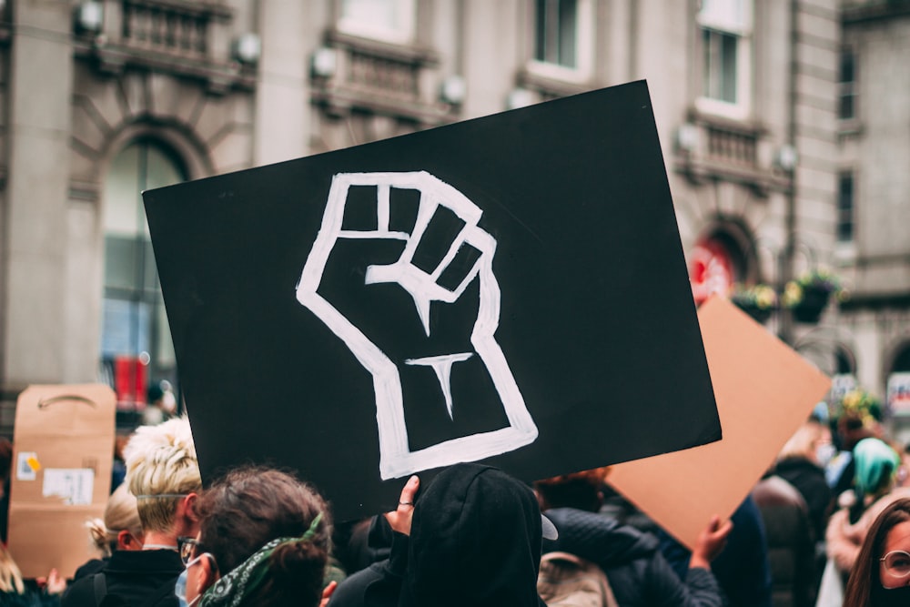 a person holding a sign with a fist drawn on it