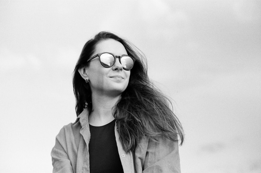 woman in black shirt and brown coat wearing sunglasses