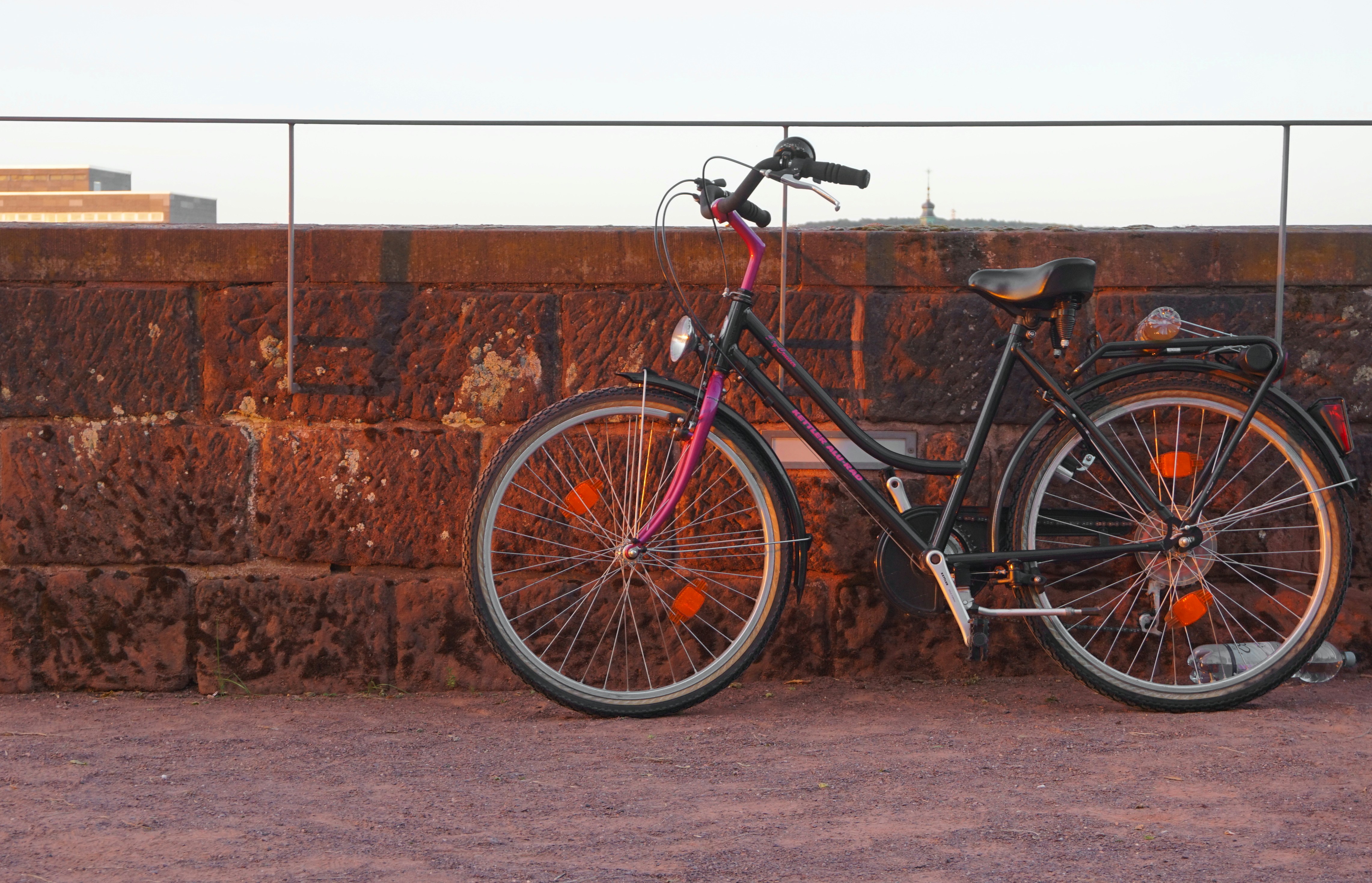 black and gray road bike leaning on brown brick wall
