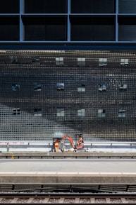 Close-up of a metro viaduct under construction with workers and cranes.