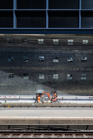 Close-up of a metro viaduct under construction with workers and cranes.