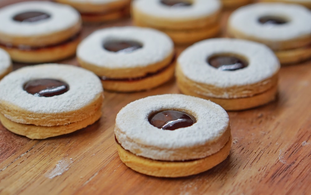 3 brown donuts on brown wooden table