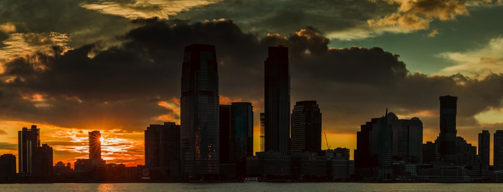 Skyline der Stadt unter bewölktem Himmel bei Sonnenuntergang