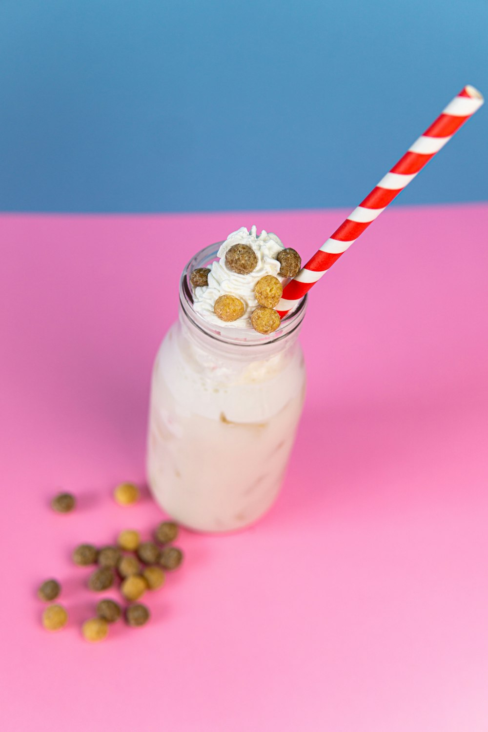 clear glass jar with white and red straw